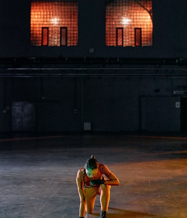 Man performing a core strength exercise in a modern gym with amber light.